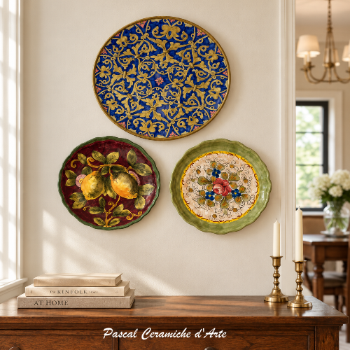 Three hand-painted Italian ceramic wall plates displayed together in an elegant home interior